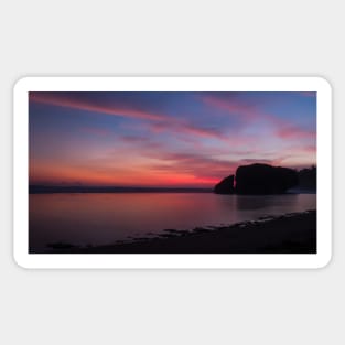 Silhouetted rock stack at a red sunset beach Sticker